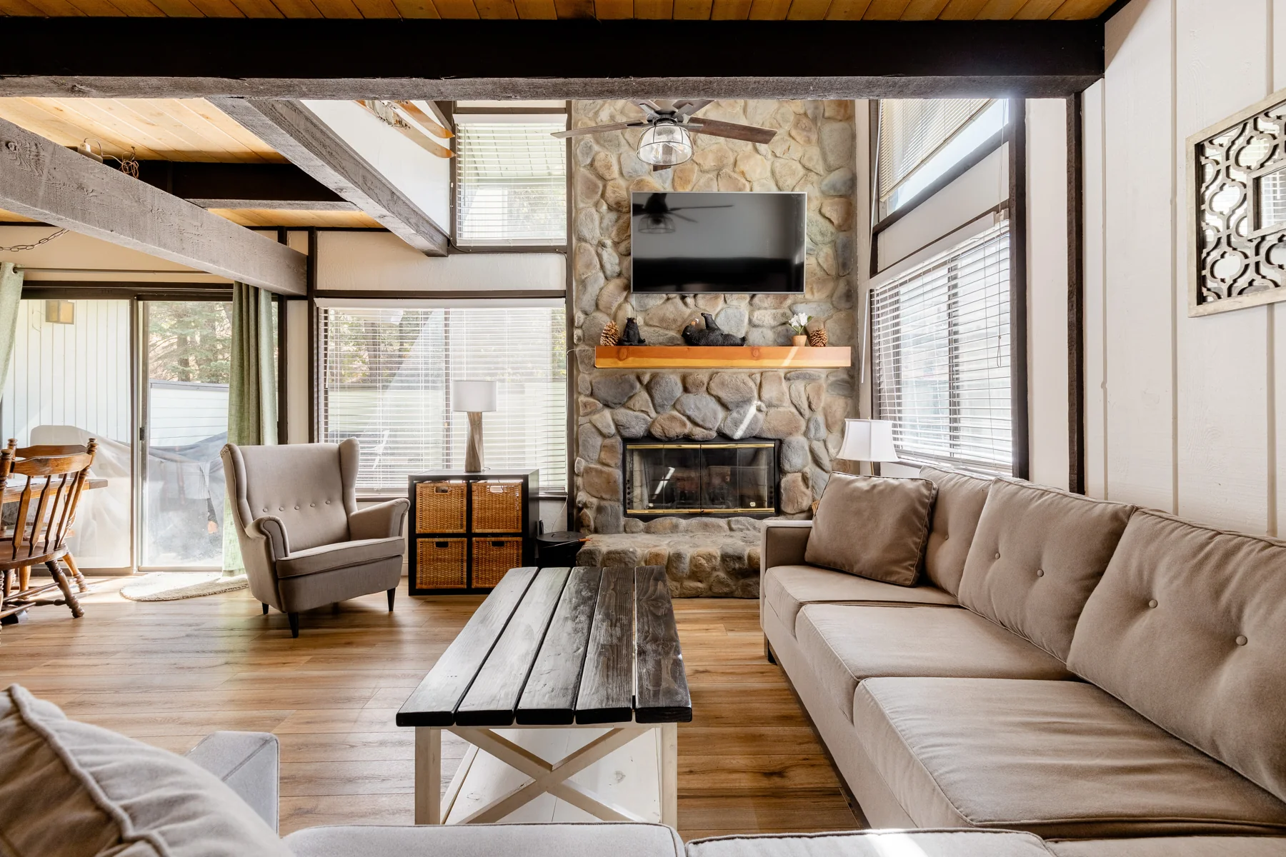 The stone fireplace and comfortable seating in the open living room